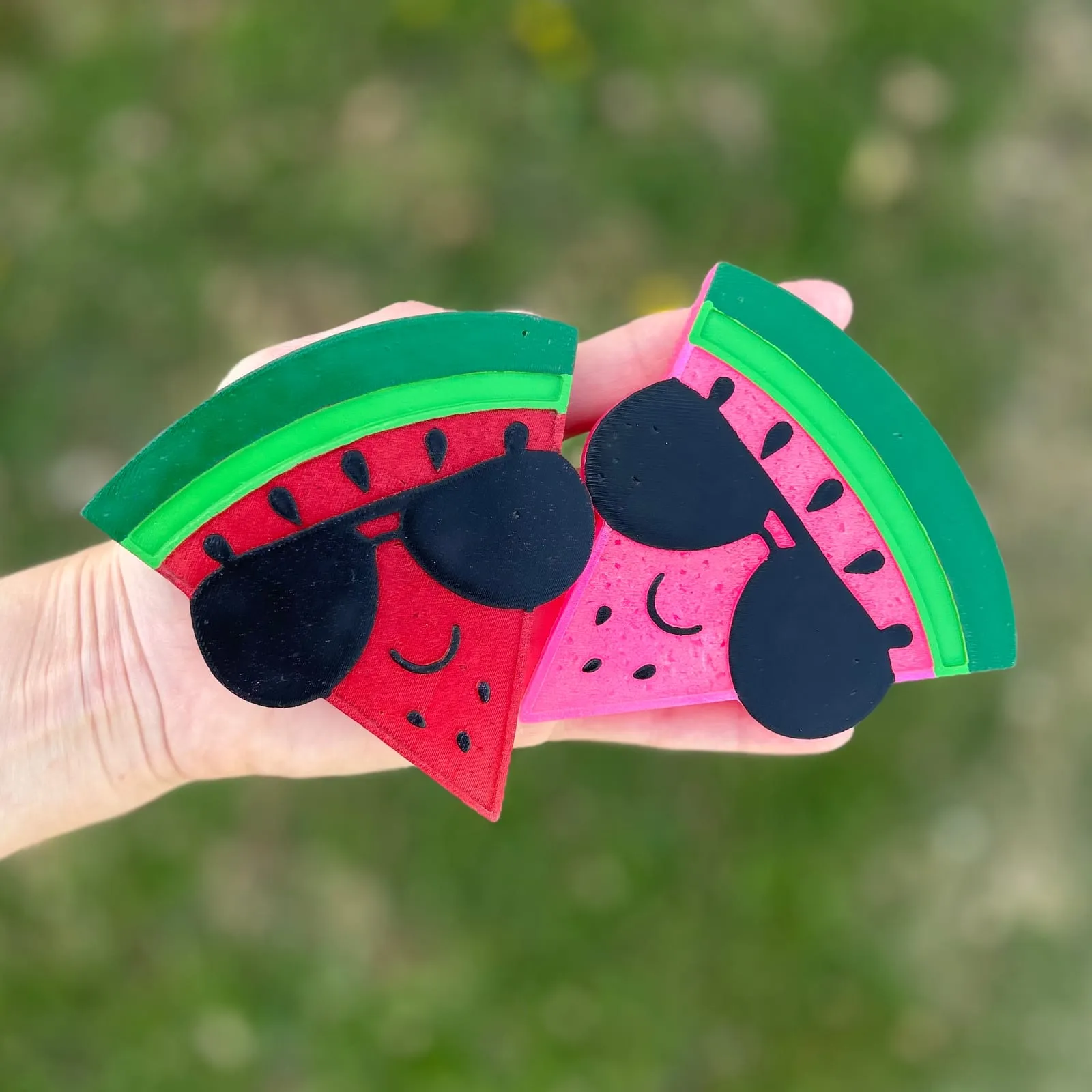 Handmade watermelon slice car freshie with a smiley face and little black sunglasses, a cute scented aroma bead car air freshener shown in red and pink versions.